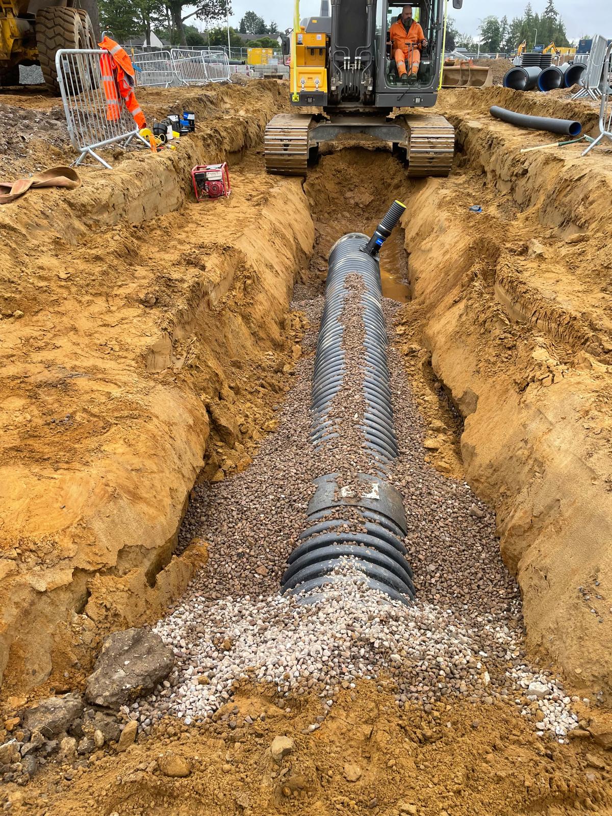 Drainage trench excavation with perforated pipe laid to falls
