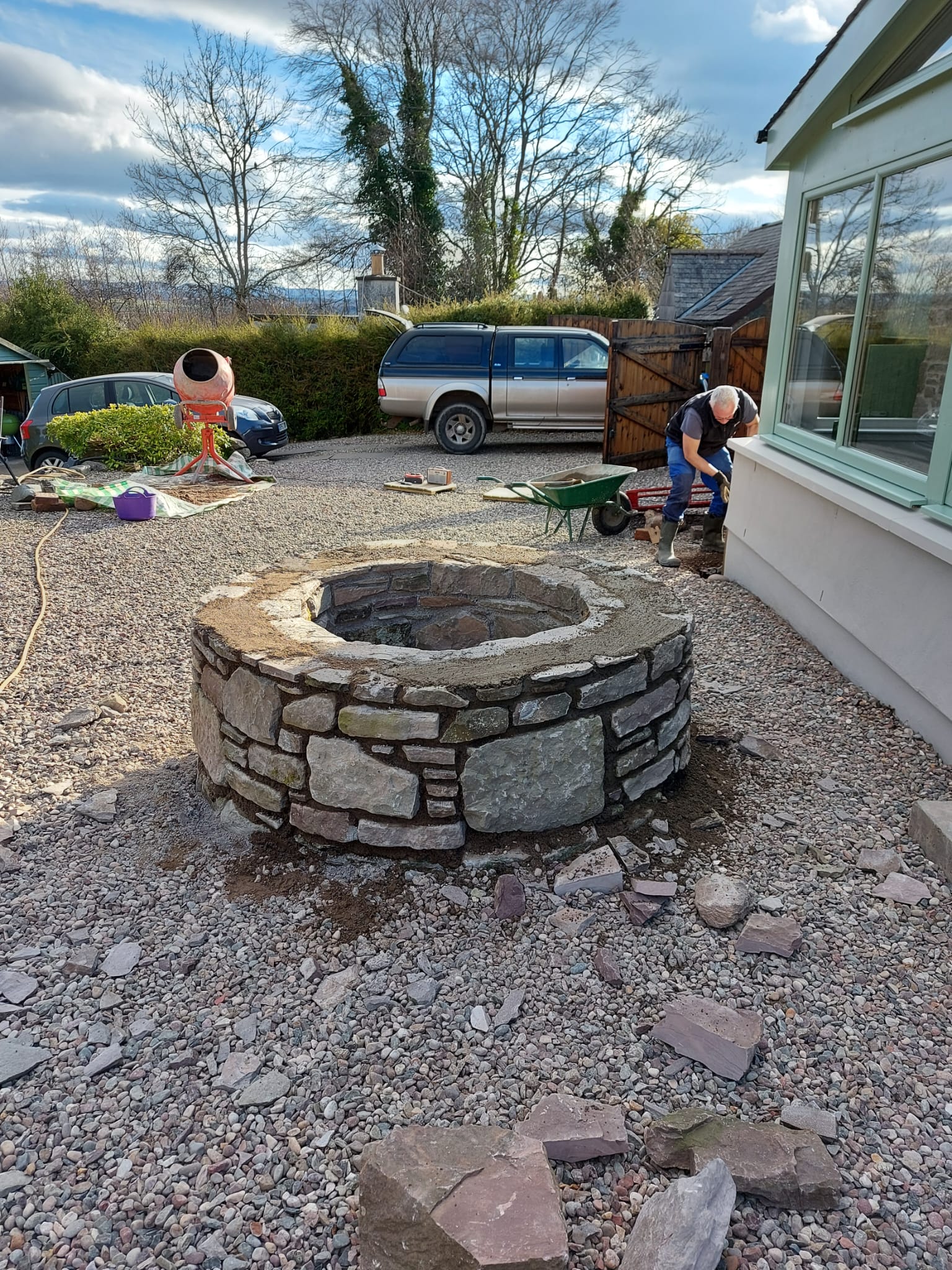 Circular stone fire pit feature built from coursed natural stone
